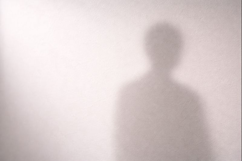 Ombre humaine floue projetée sur un mur clair, évoquant la détresse liée au suicide.