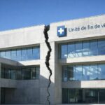 Bâtiment institutionnel contemporain en béton et verre, vide de toute présence humaine, fracturé verticalement, avec l’inscription « Unité de fin de vie », éclairé par la lumière naturelle du jour.