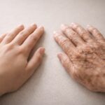 Deux mains féminines côte à côte, l’une jeune et lisse, l’autre très âgée et marquée, symbolisant la dignité partagée entre générations.