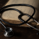 Un stéthoscope posé sur un livre de comptabilité ouvert, symbolisant le conflit des logiques.