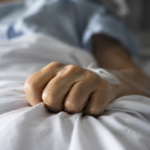 Peur de souffrir : main crispée sur un drap d’hôpital
