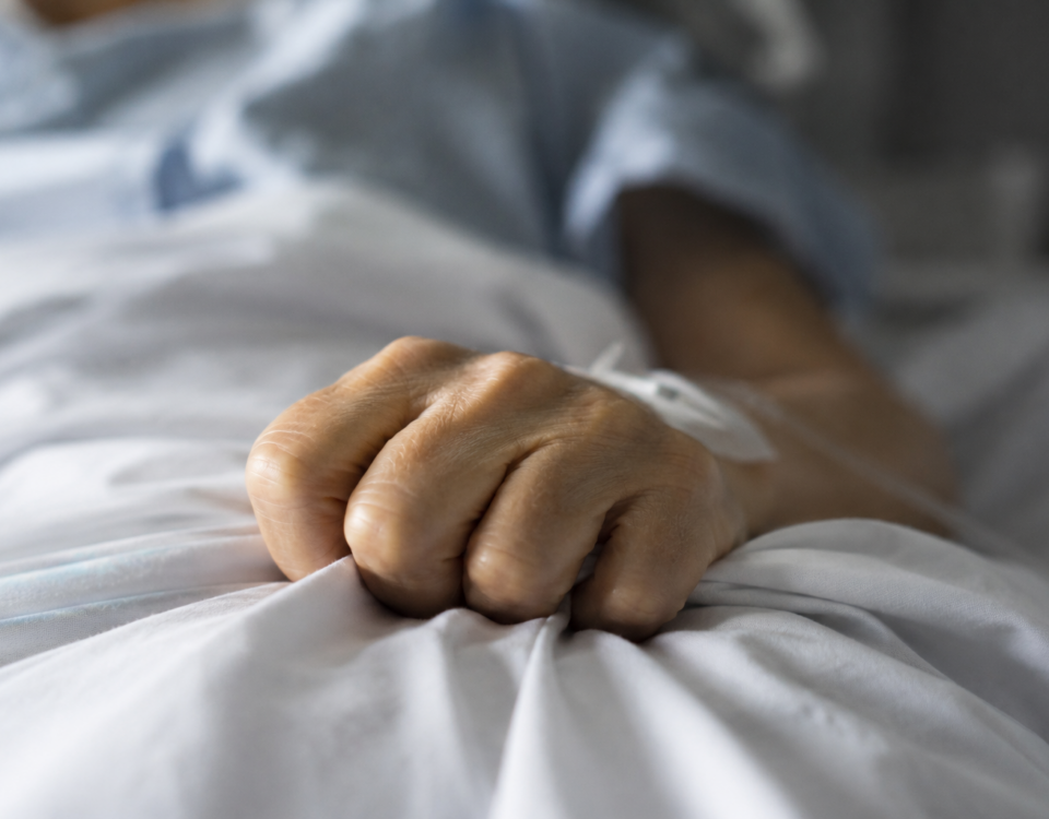 Peur de souffrir : main crispée sur un drap d’hôpital
