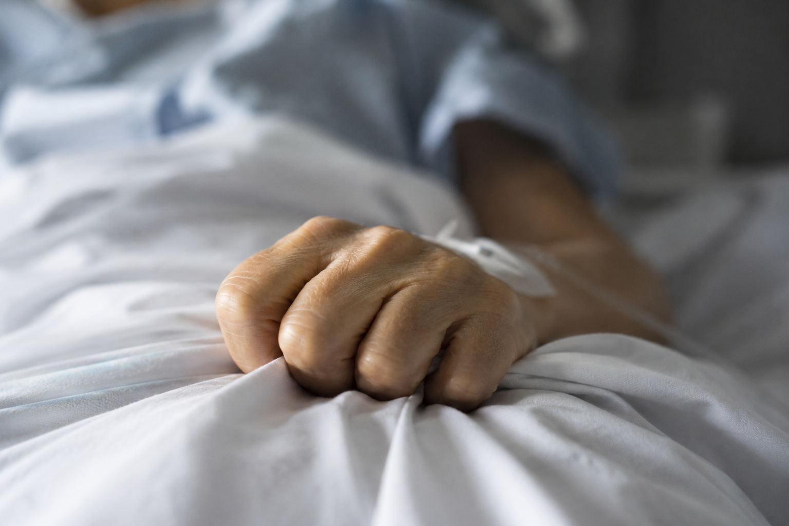 Peur de souffrir : main crispée sur un drap d’hôpital