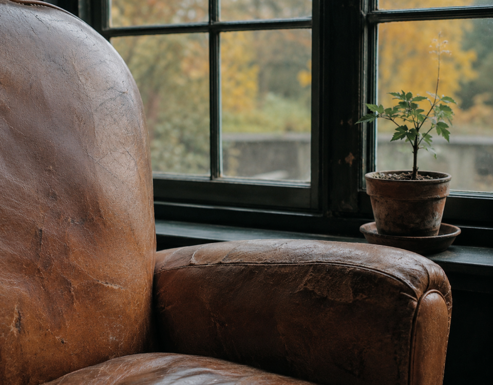 Fauteuil en cuir usé près d'une fenêtre lumineuse, symbolisant l'espace d'écoute et d'attente en clinique.