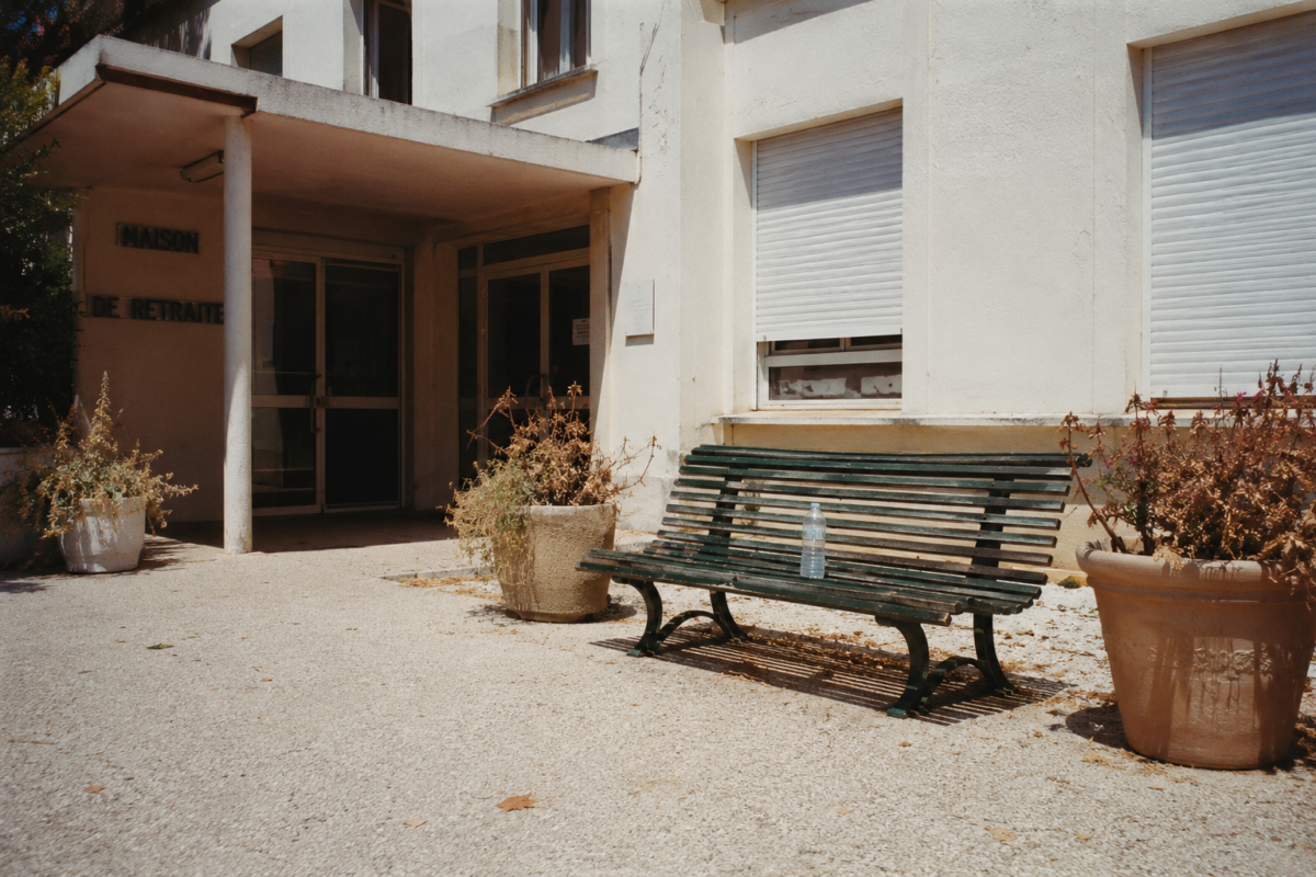 Banc vide devant une maison de retraite par une journée de canicule.