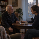 Une fille échange avec son père malade autour d’une table et rapproche doucement sa tasse vers lui.